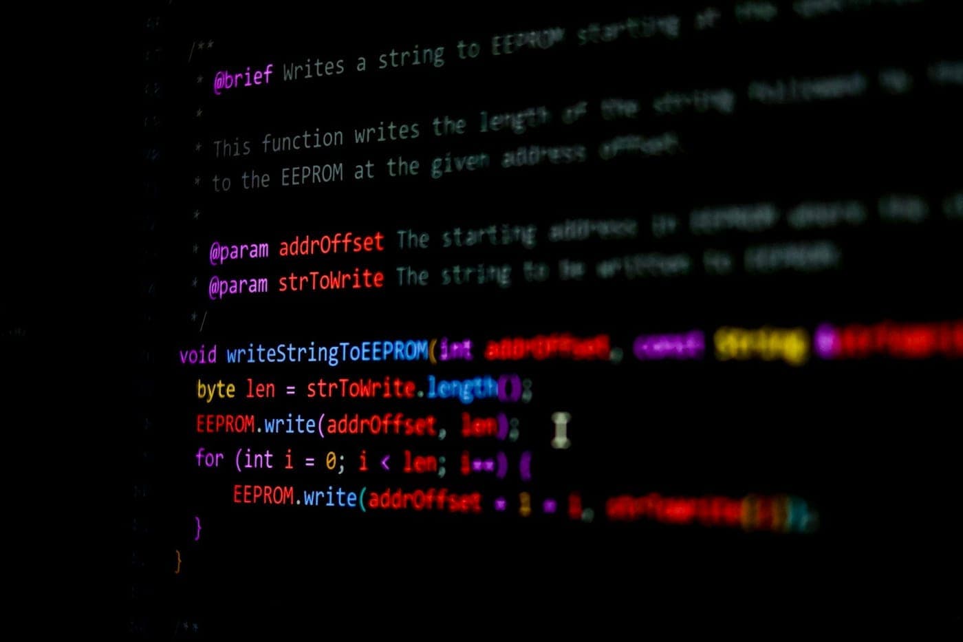 Close-up of syntax-highlighted source code on a dark screen with shallow depth of field